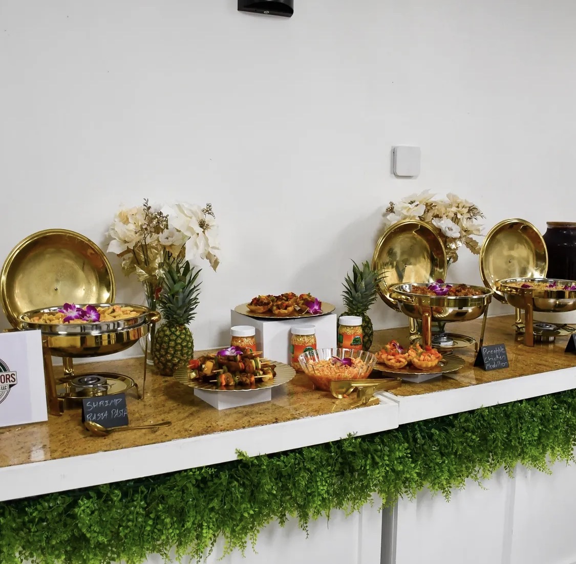 Full buffet table with pineapples and orchids