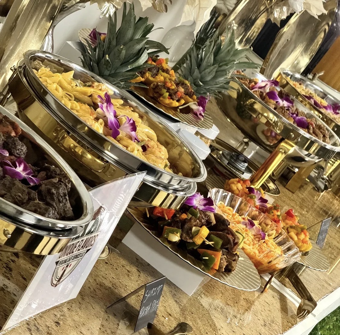 Gold chafing dishes filled with Caribbean dishes